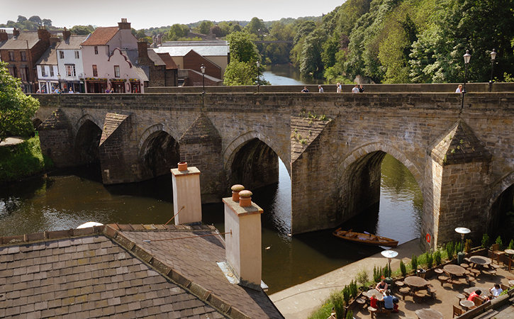 view of Elvet Bridge in Durham City with outdoor dining area next to River Wear
